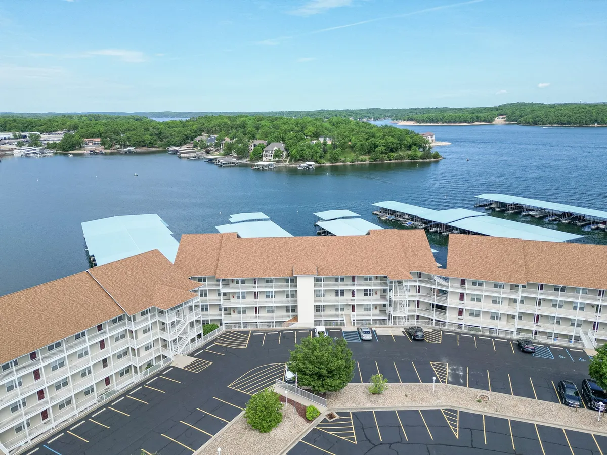 This exterior image showcases the waterfront, marina, hotel structure, and parking area, capturing the essence of lakeside living and water-based activity. The view reveals sparkling water, boats docked at the marina, and the overall inviting atmosphere of the lakeshore.